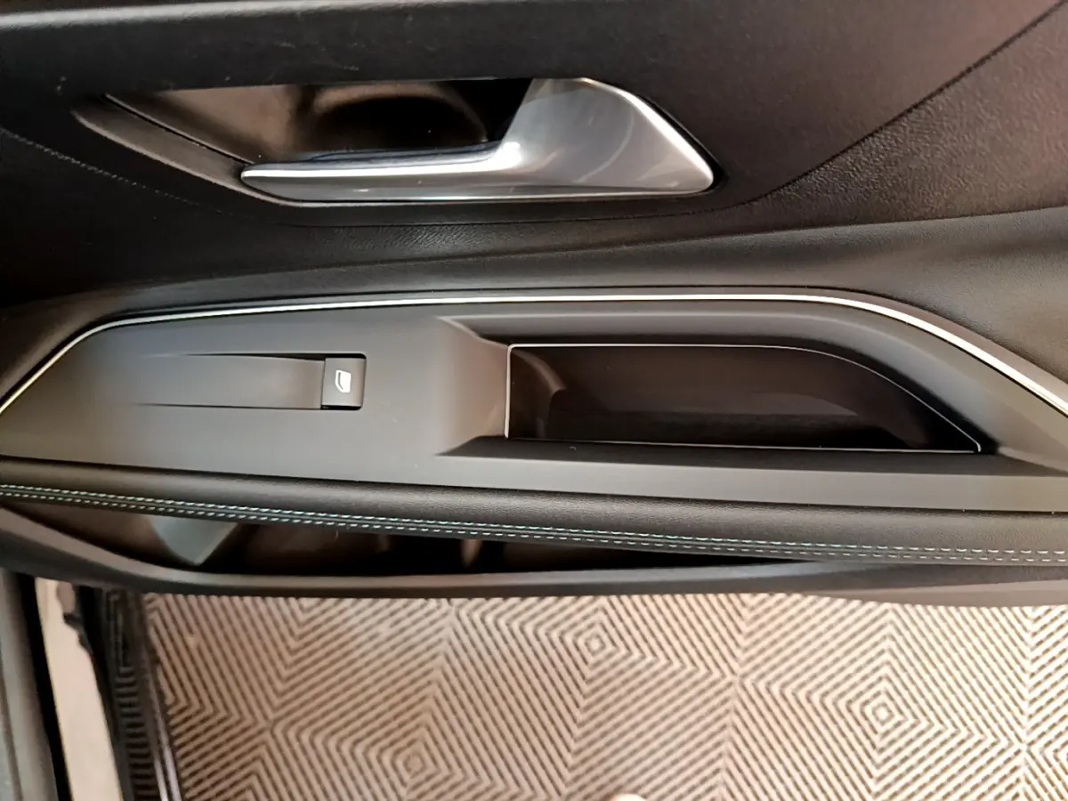 Poignée intérieure et commande de lève-vitre côté conducteur du Peugeot 3008 noir, finition Allure Pack 2022.