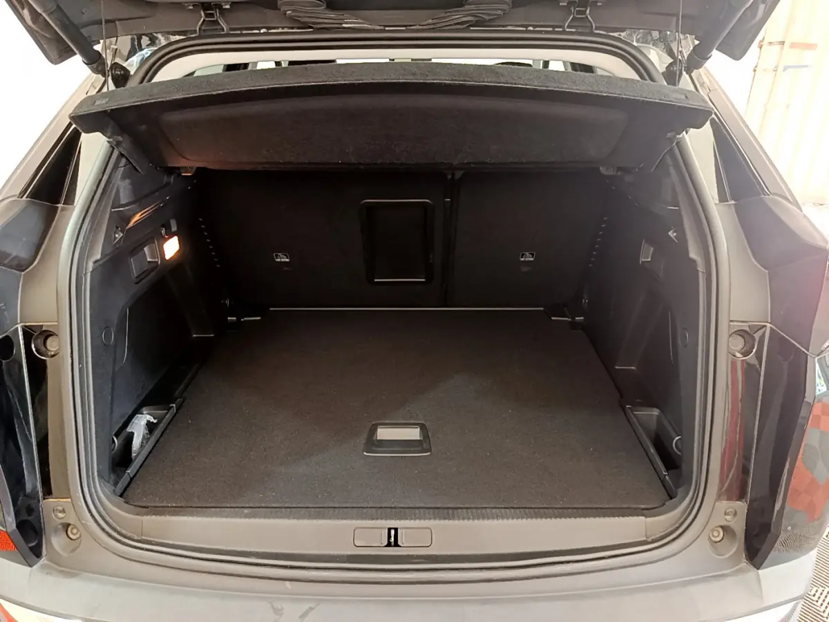 Coffre ouvert noir du Peugeot 3008 BlueHDi 130 S&S EAT8 Allure Pack vu de l'arrière, espace de chargement spacieux et propre.