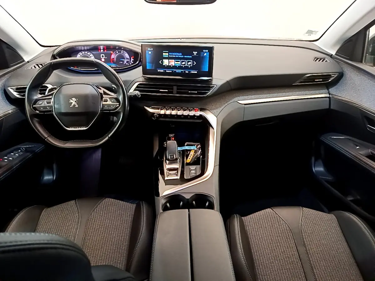Intérieur du Peugeot 3008 2022, vue avant centrée sur tableau de bord et volant cuir noir multifonctions.