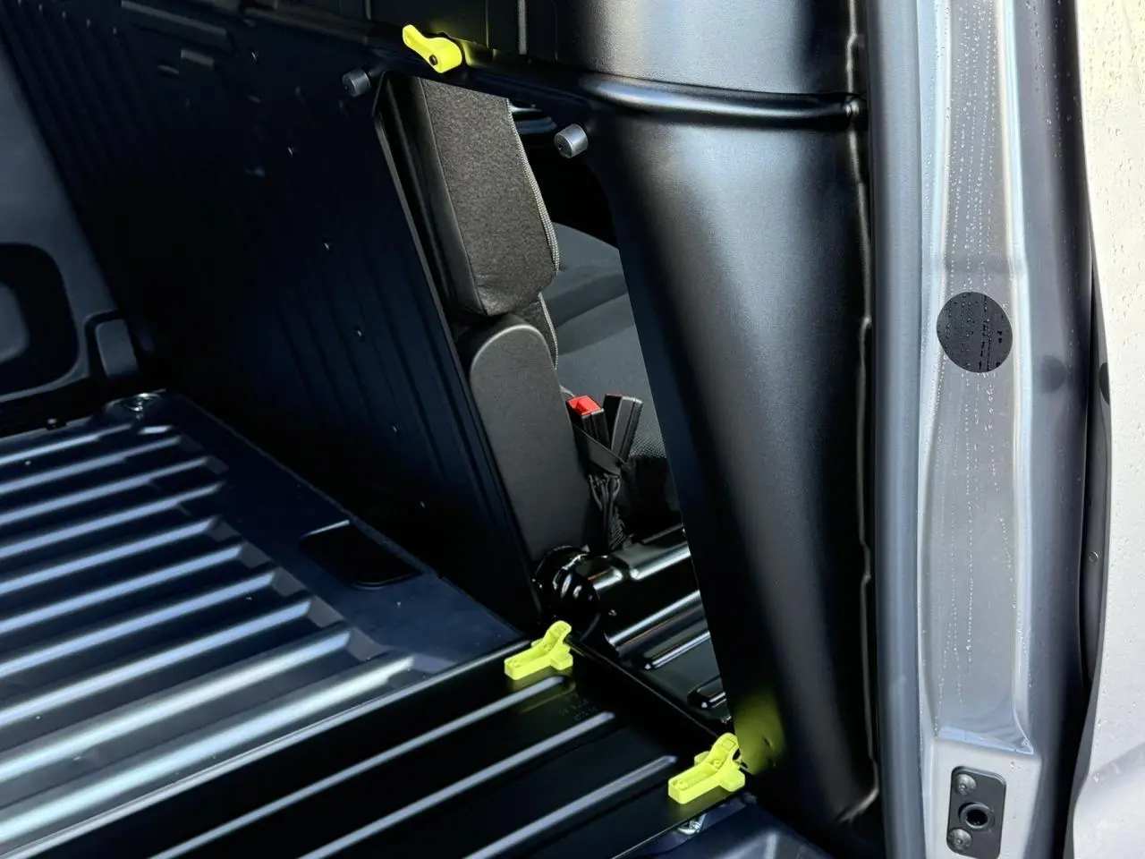 Détail intérieur montrant la cloison et la banquette rabattable du Citroën Berlingo Van gris Artense côté droit