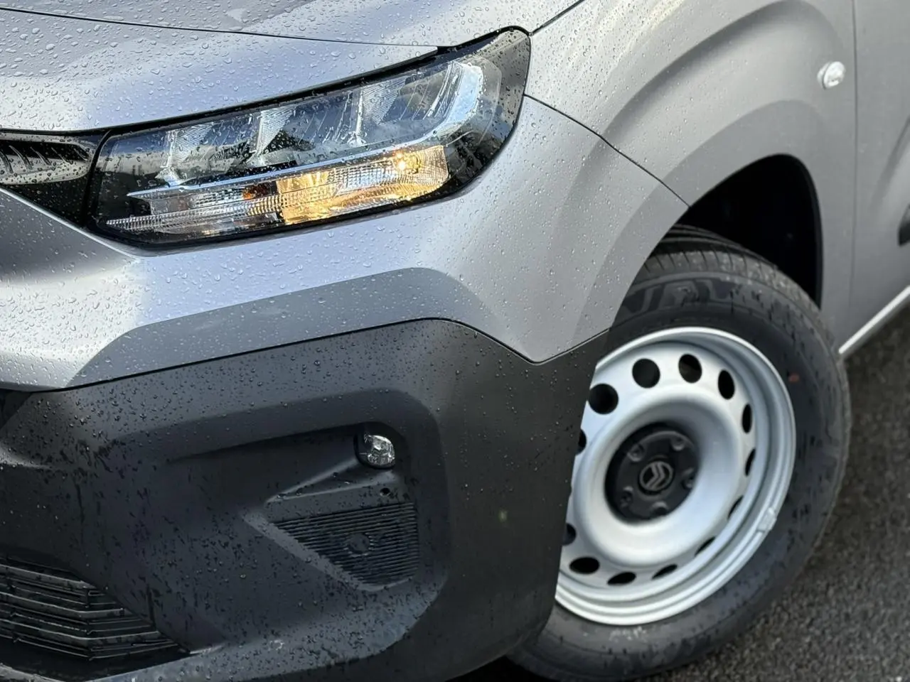 Gros plan sur l'avant droit gris Artense du Citroën Berlingo 2025 avec phare antibrouillard allumé et jante tôle.