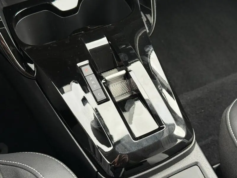 Gros plan sur la console centrale noire brillante avec levier de vitesses automatique de la Citroën C3 électrique 2025.