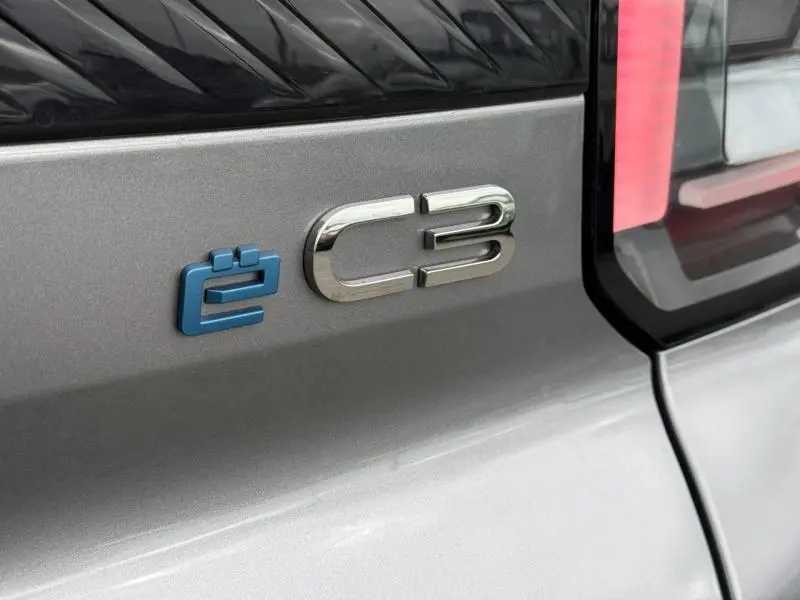 Gros plan sur l'arrière droit gris Mercury d'une Citroën C3 électrique 2025 avec logo bleu ëC3 et feu arrière vertical.