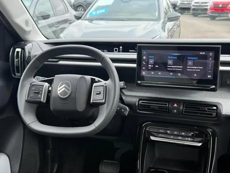 Vue intérieure du tableau de bord et volant de la Citroën C3 électrique 2025, avec écran tactile et commandes intégrées.