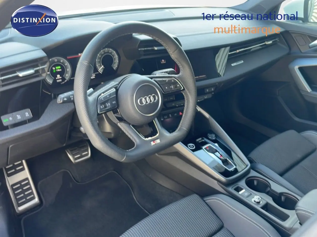 Vue intérieure de l'Audi A3 Sportback 2025, tableau de bord et volant multifonction en cuir noir avec finitions modernes.