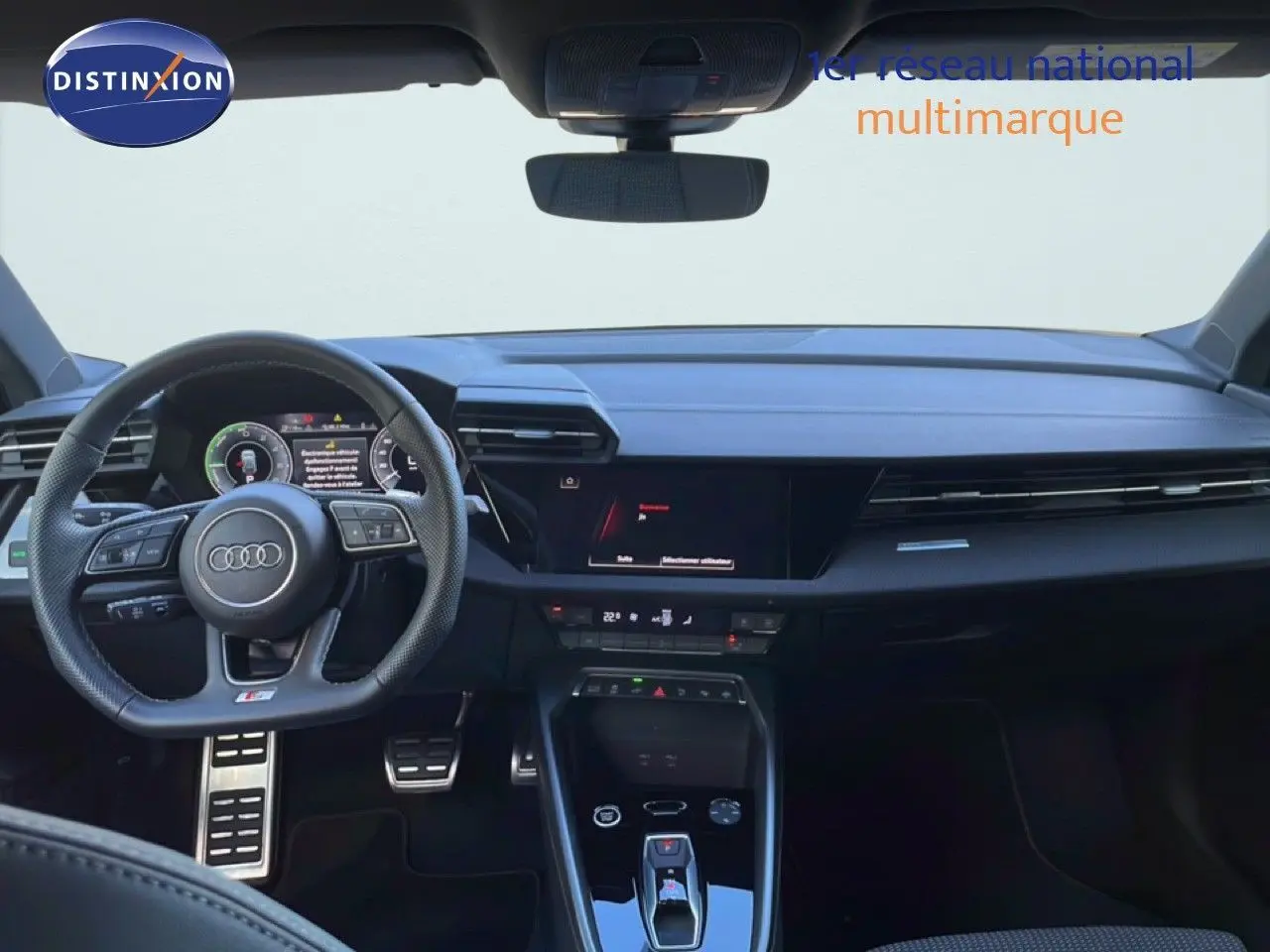 Vue intérieure avant de l'Audi A3 Sportback 40 TFSIe blanc Ibis, tableau de bord et volant multifonction S-Line visibles.