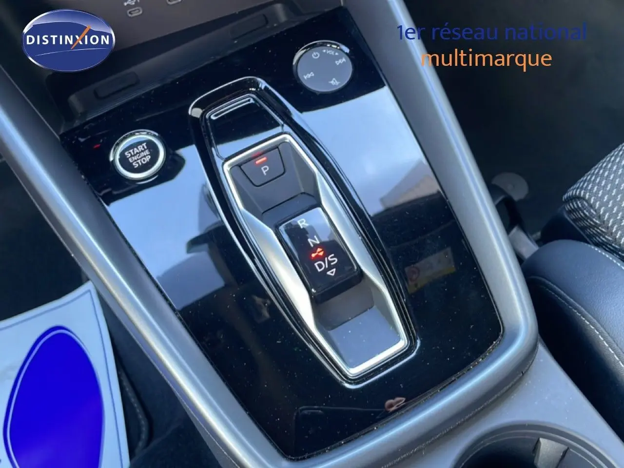 Gros plan sur la console centrale noire brillante avec levier de vitesses électronique et bouton start/stop d'une Audi A3 Sportback 2025.