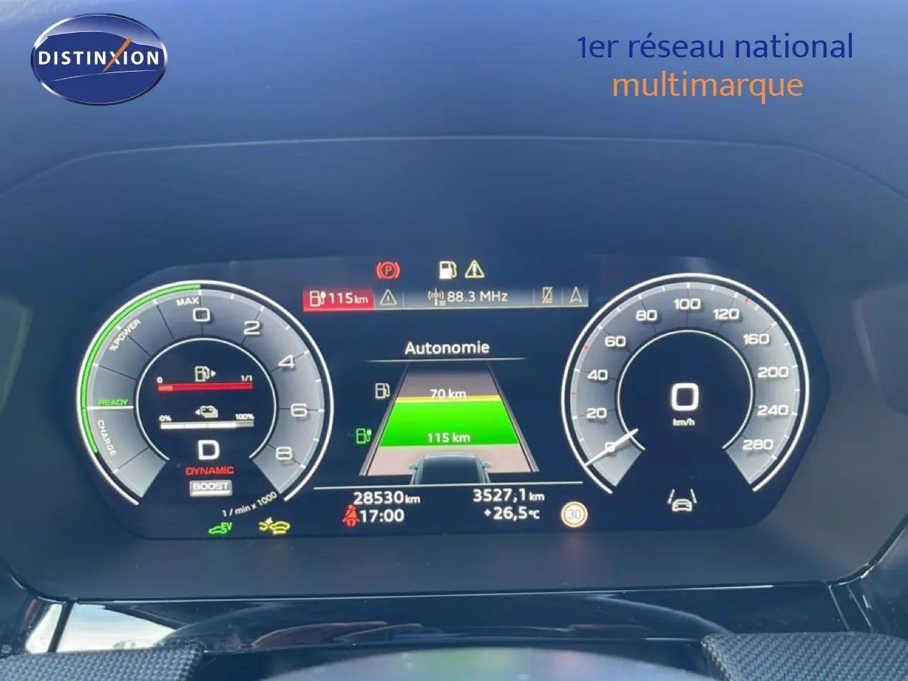 Tableau de bord numérique de l'Audi A3 Sportback blanc, affichant autonomie et compte-tours en vue frontale.