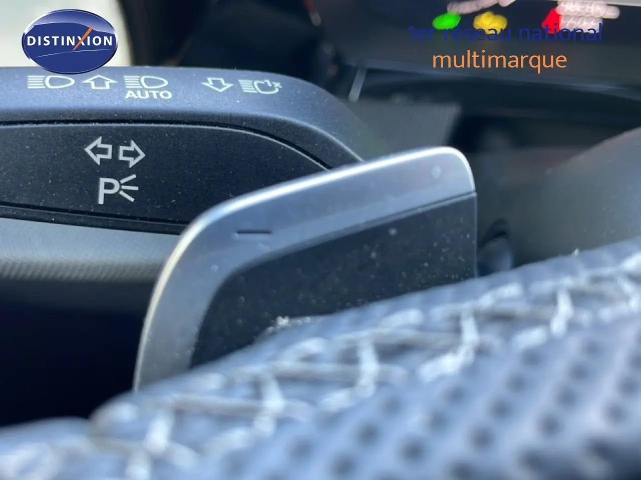 Gros plan sur la commande de clignotant et palette de changement de vitesse dans l'habitacle de l'Audi A3 Sportback blanc Ibis 2025.