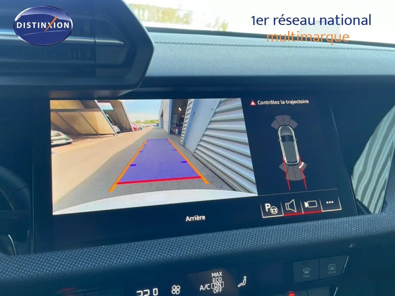 Écran de caméra de recul affichant la trajectoire d’une Audi A3 Sportback blanche vue de l’arrière, tableau de bord visible.