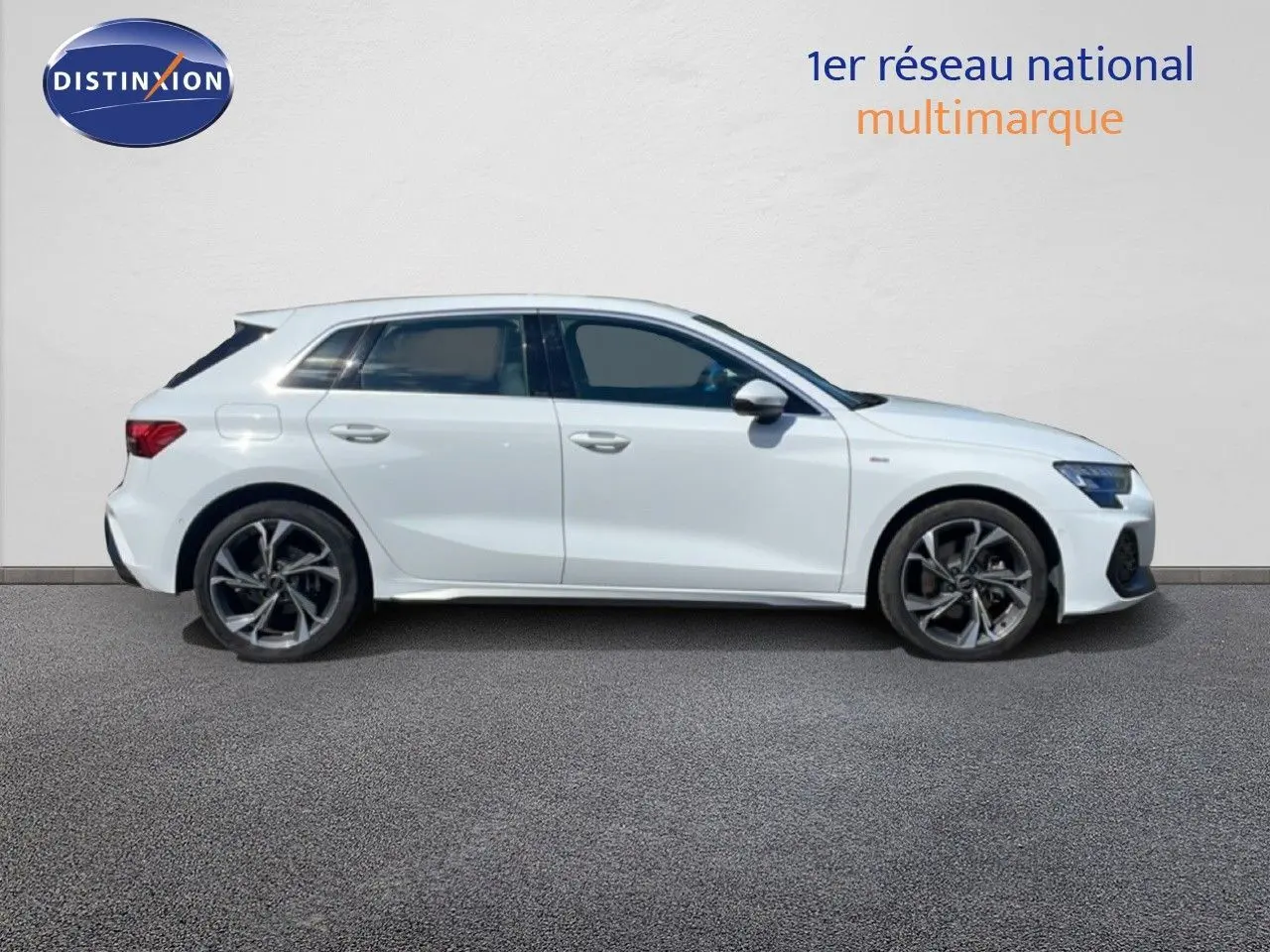 Profil droit d'une Audi A3 Sportback blanche Ibis 2025 avec jantes alliage et finition S-Line visible.