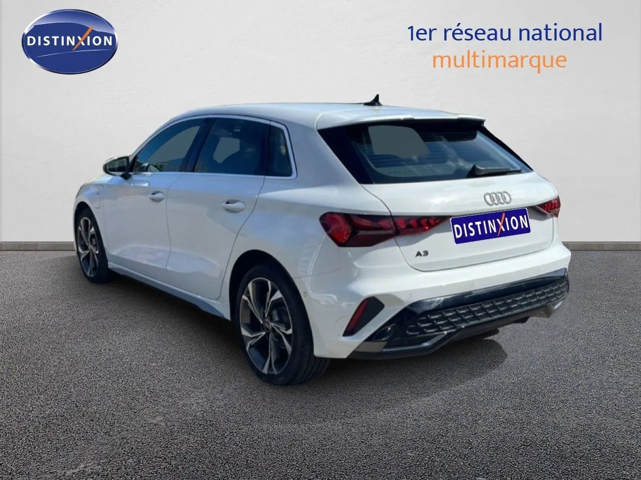 Audi A3 Sportback blanc Ibis en 3/4 arrière droit, mettant en valeur ses feux arrière LED et ses jantes alliage.