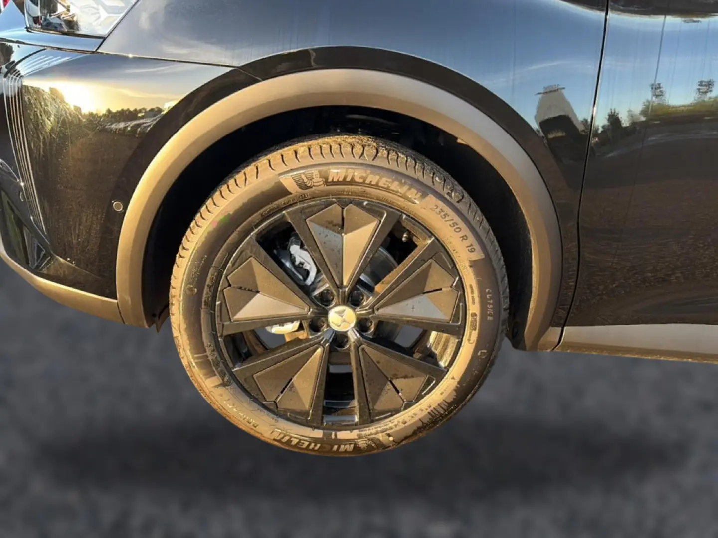 Gros plan sur la roue avant gauche noire du DS7 1.5 BlueHDi 130 avec jante alu noire au design géométrique.