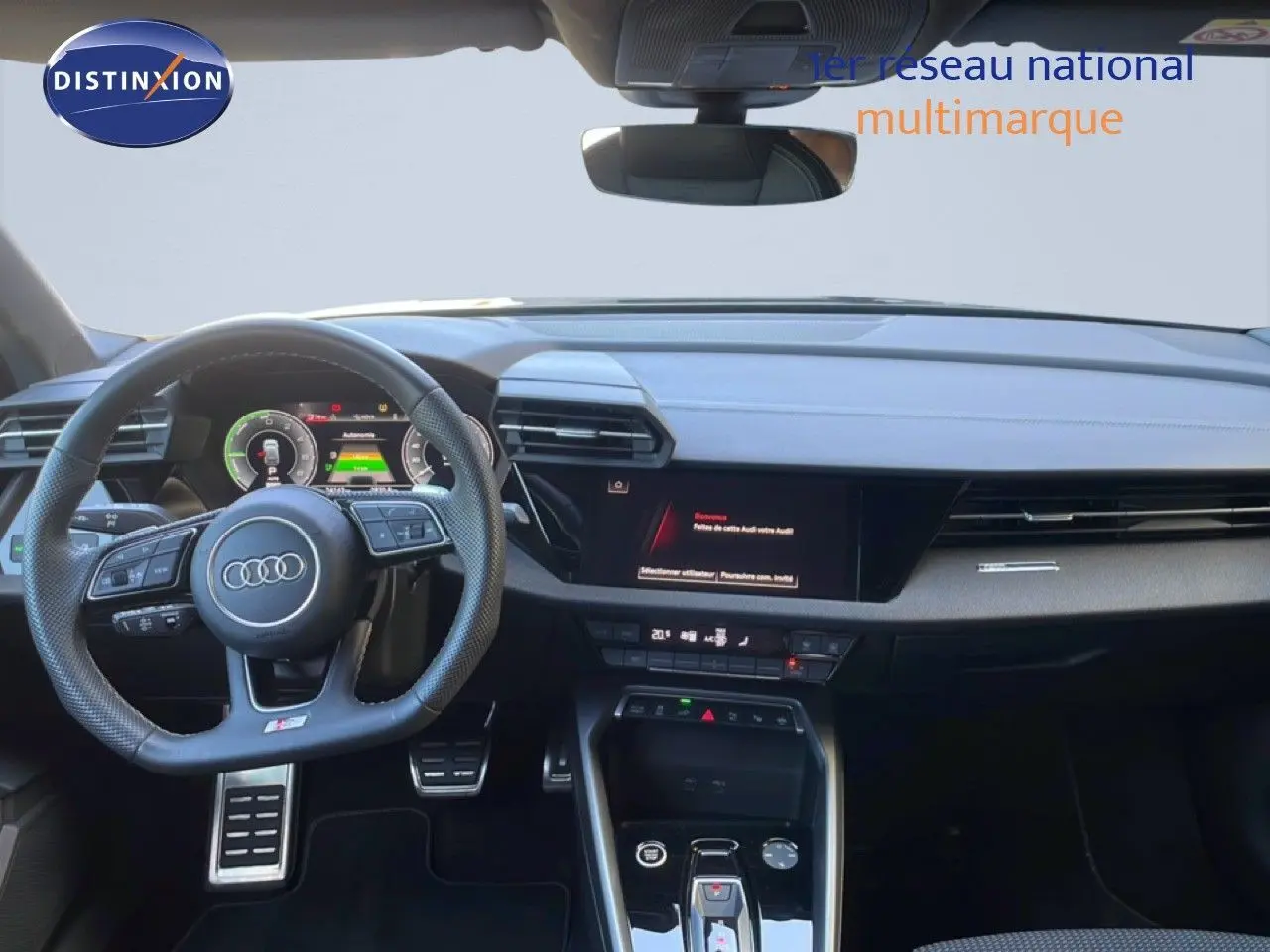 Vue intérieure de l'Audi A3 Sportback 2025 noire, tableau de bord moderne avec volant multifonction et écran digital.