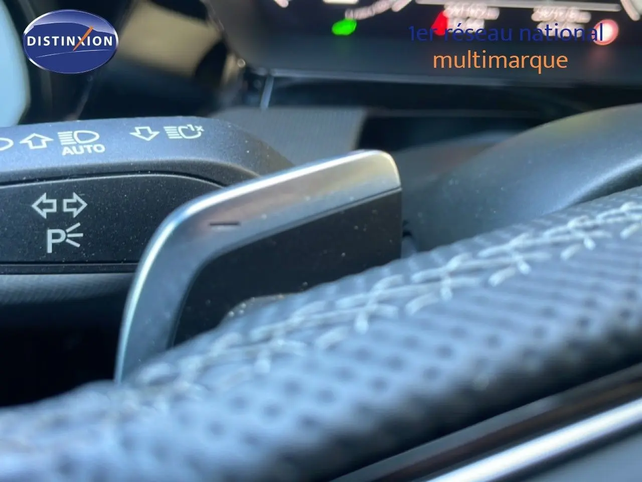 Détail du volant noir perforé et palette de changement de vitesse sur Audi A3 Sportback 40 TFSIe 2025.