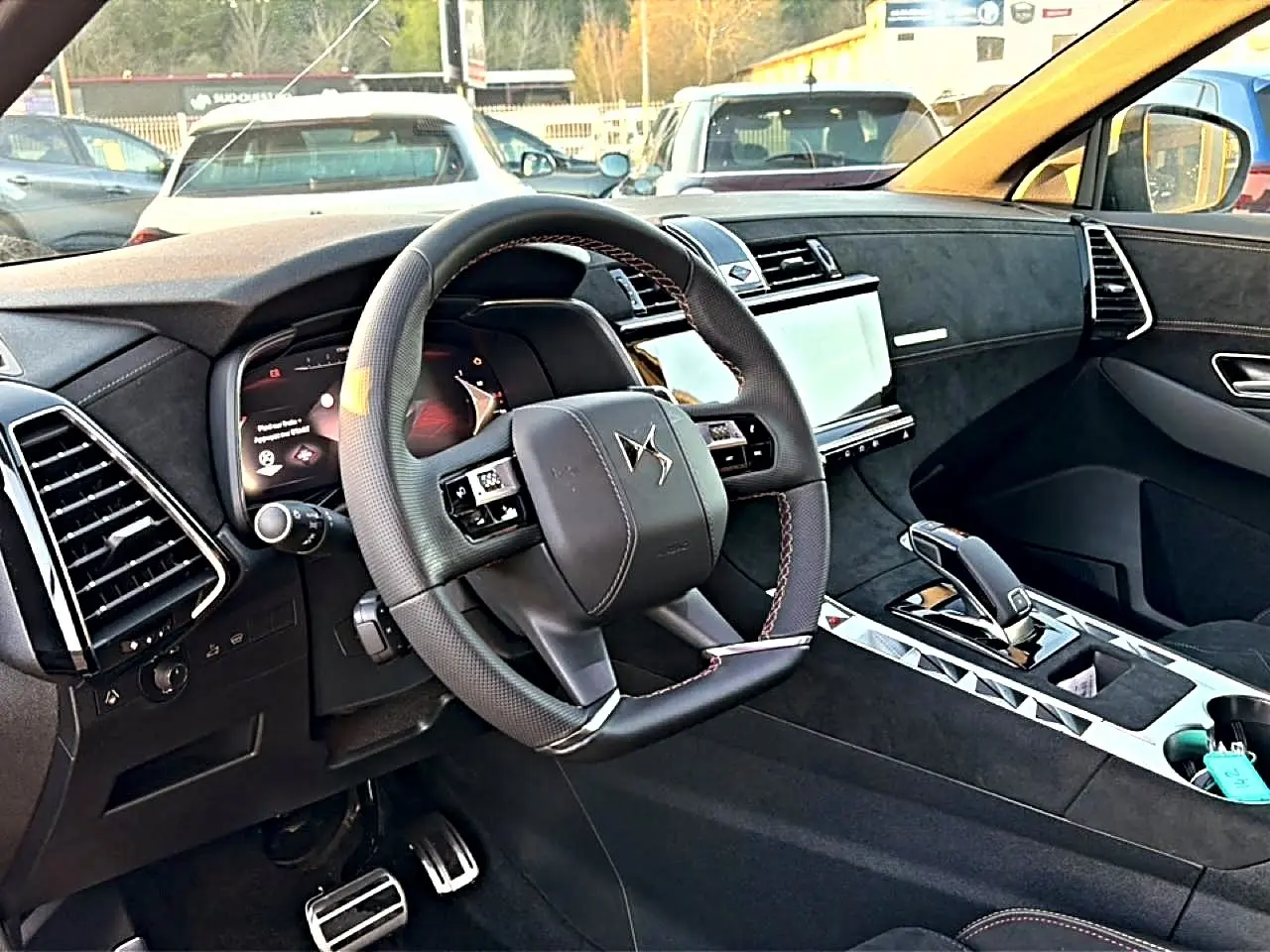 Intérieur noir du DS7 1.5 BlueHDi 130 Performance Line, vue côté conducteur sur volant et console centrale moderne.