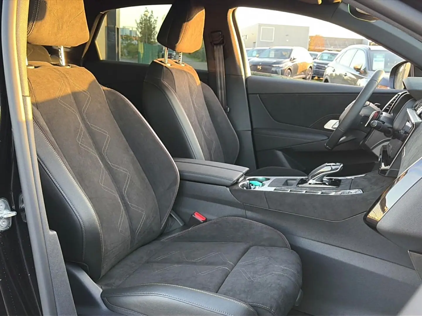 Vue intérieure côté conducteur du DS7 1.5 BlueHDi noir, sièges en alcantara avec surpiqûres et console centrale élégante.