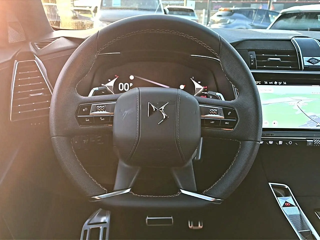 Vue intérieure centrée sur le volant cuir noir du DS7 1.5 BlueHDi 130 avec tableau de bord numérique et écran tactile GPS.