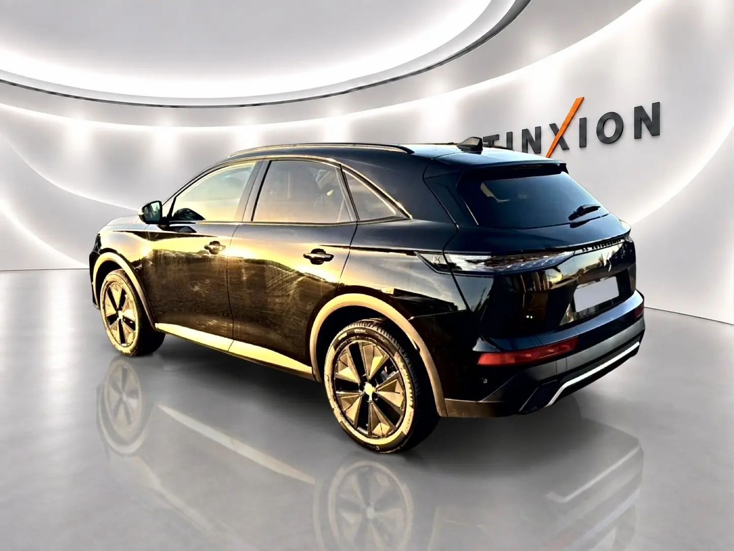 DS7 1.5 BlueHDi 130 noir en 3/4 arrière droit, avec jantes alliage et vitres arrière surteintées dans un showroom lumineux.