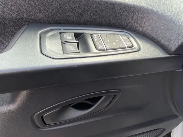 Poignée de porte intérieure côté gauche avec commandes des vitres et rétroviseurs du Renault Trafic Fourgon blanc 2025.