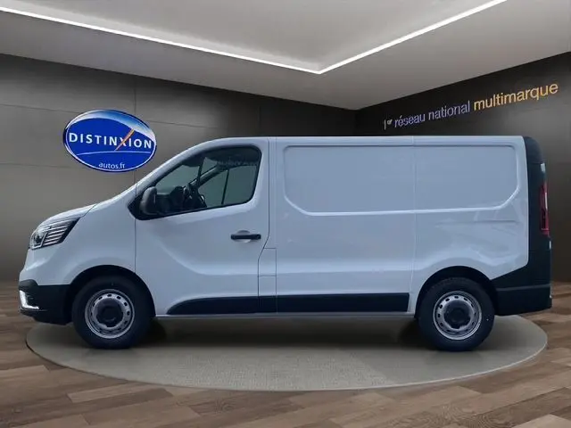 Renault Trafic Fourgon blanc en profil côté gauche, présenté en intérieur sur fond sombre avec logo Distinxion.