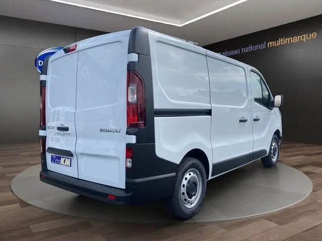 Vue 3/4 arrière droite d'un Renault Trafic Fourgon blanc 2025 avec portes arrière battantes et jantes acier simples.