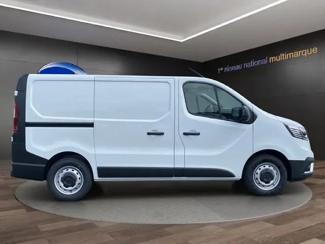 Profil droit d'un fourgon Renault Trafic blanc L1H1 2025 avec portes latérales et jantes acier simples.