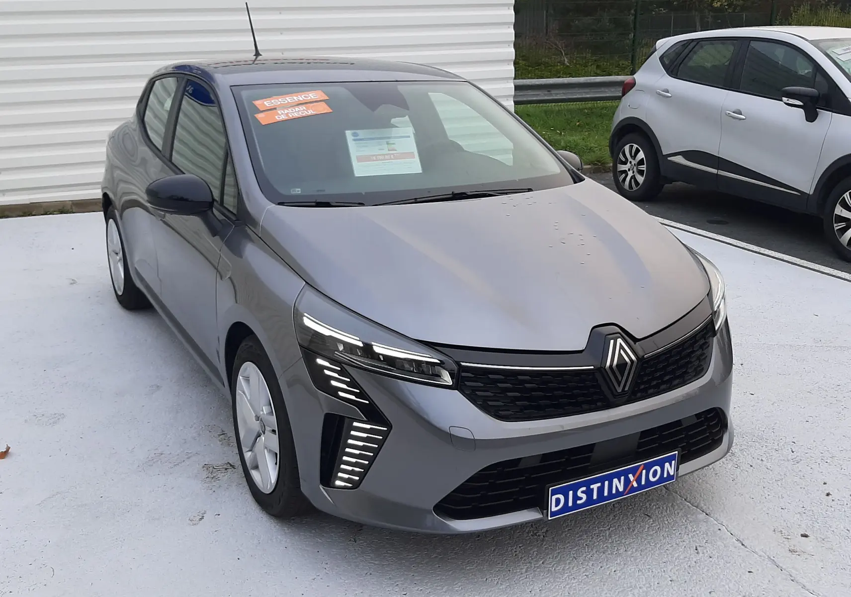 Renault Clio V TCE 90ch Evolution gris schiste vue 3/4 avant avec feux LED et calandre noire distinctive.