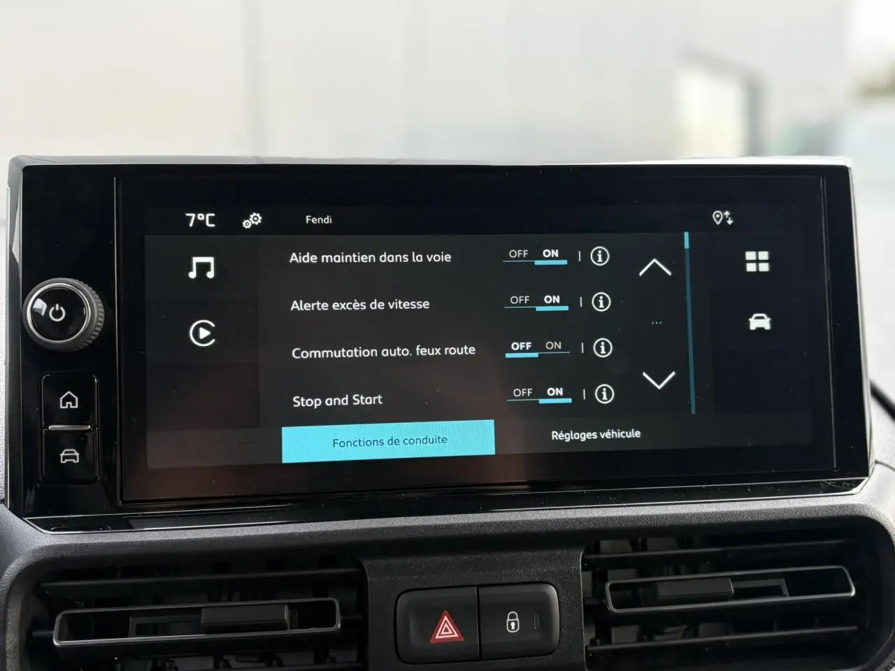 Écran tactile central du Citroën Berlingo 2025 affichant les réglages d'aide à la conduite, tableau de bord noir.