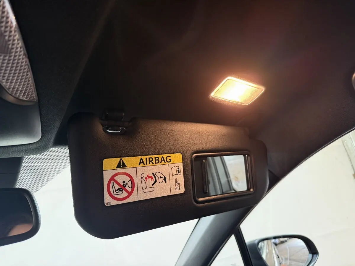 Détail du pare-soleil côté conducteur avec miroir et avertissement airbag dans un Toyota C-HR gris foncé.