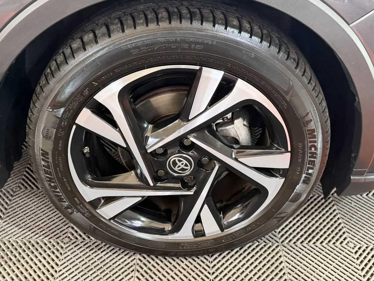 Gros plan sur la jante alliage noire et argentée du Toyota C-HR gris foncé, avec pneu Michelin visible.