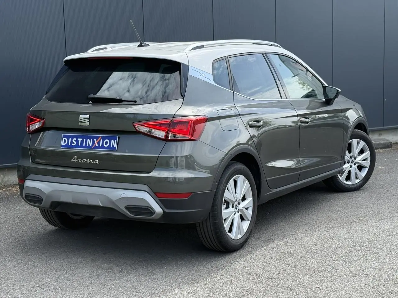Vue 3/4 arrière droite d’un SEAT Arona gris Cliff avec vitres arrière surteintées et jantes alliage 17 pouces.