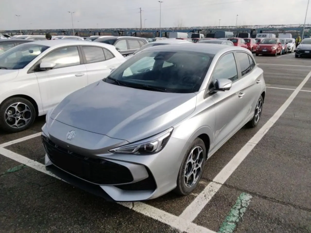 MG3 1.5 Hybrid+ 195 Luxury argent silver en 3/4 avant droit sur parking avec jantes alliage distinctives.