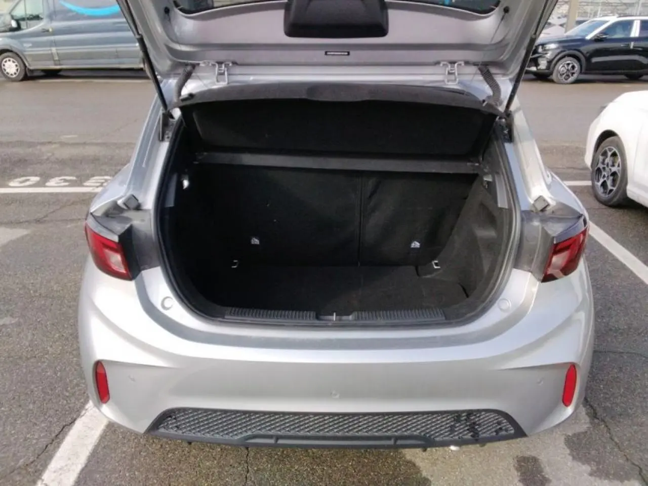Vue arrière ouverte du coffre d'une MG3 1.5 Hybrid+ 195 Luxury argent métallisé, montrant l'espace de chargement vide.