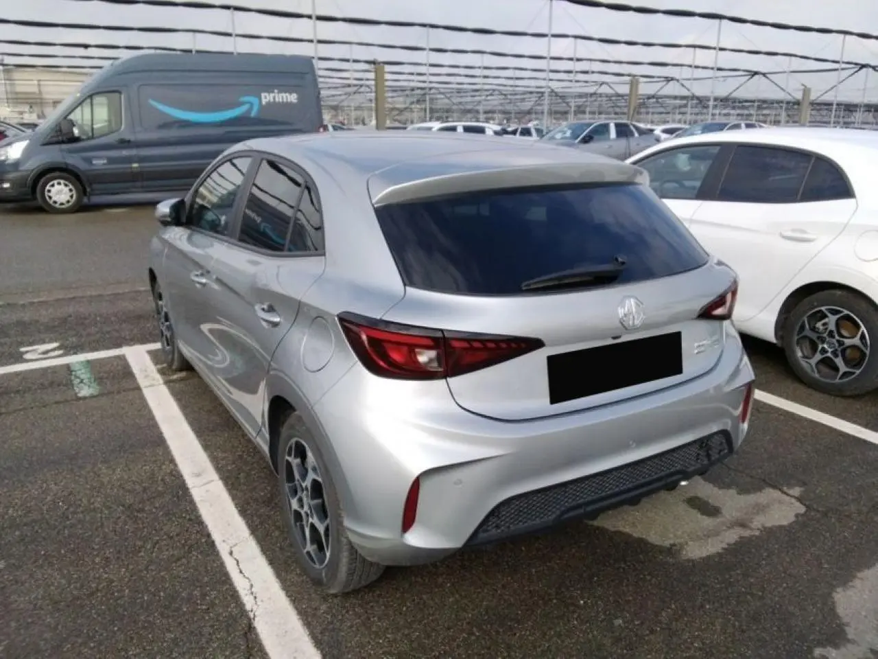 Vue 3/4 arrière droite d'une MG3 1.5 Hybrid+ 195 Luxury argent métallisé avec vitres teintées et jantes alliage.