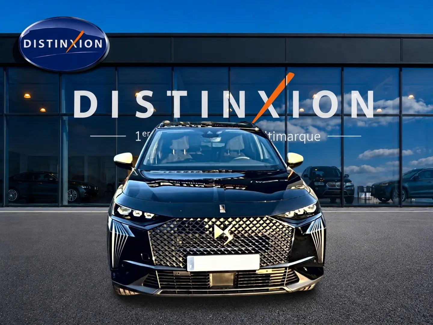Vue avant du DS7 noir 2026 avec calandre distinctive et phares LED, devant une vitrine de concession Distinxion.
