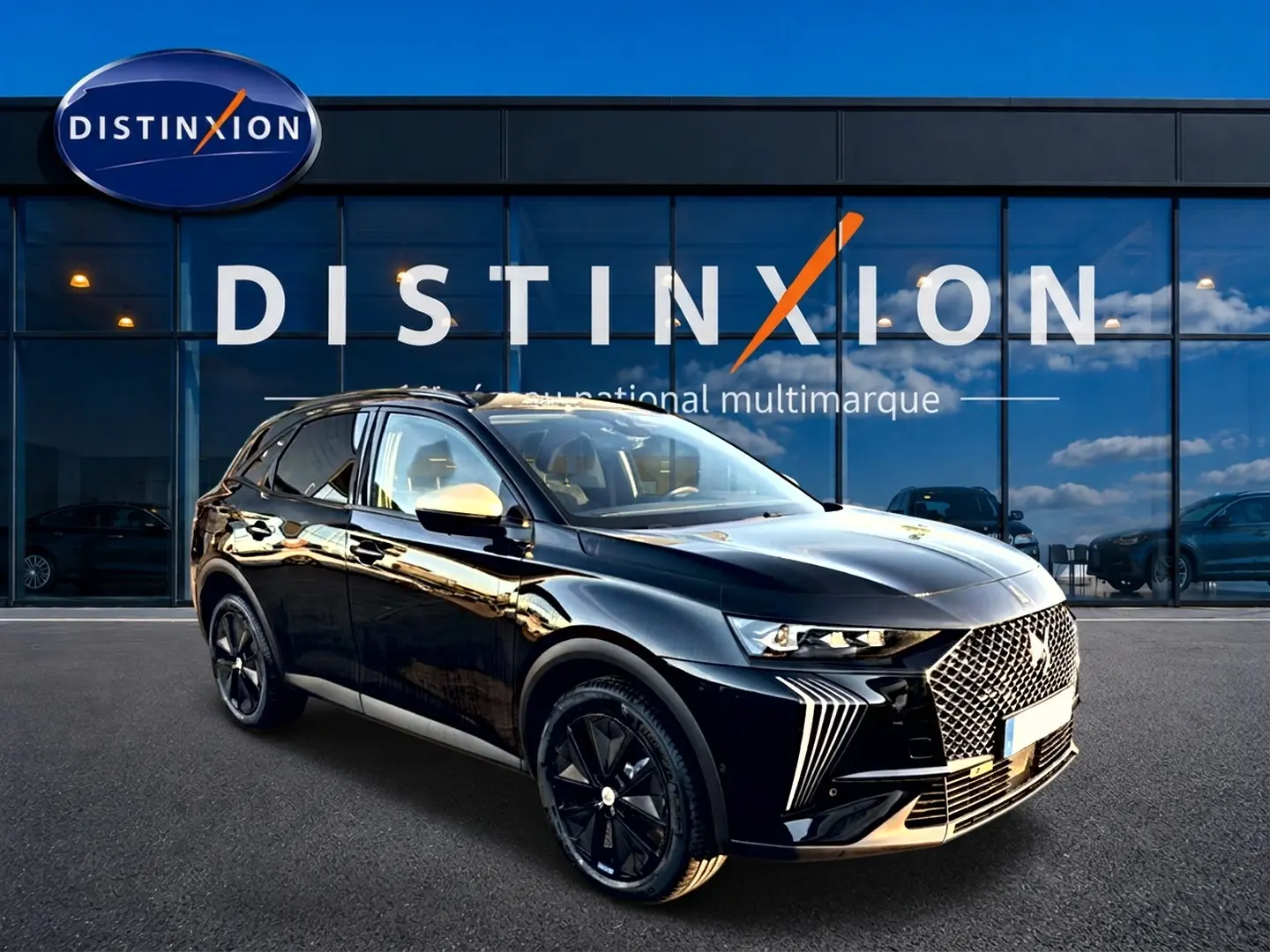 DS7 noir 3/4 avant droit avec calandre distinctive et jantes noires devant showroom Distinxion.
