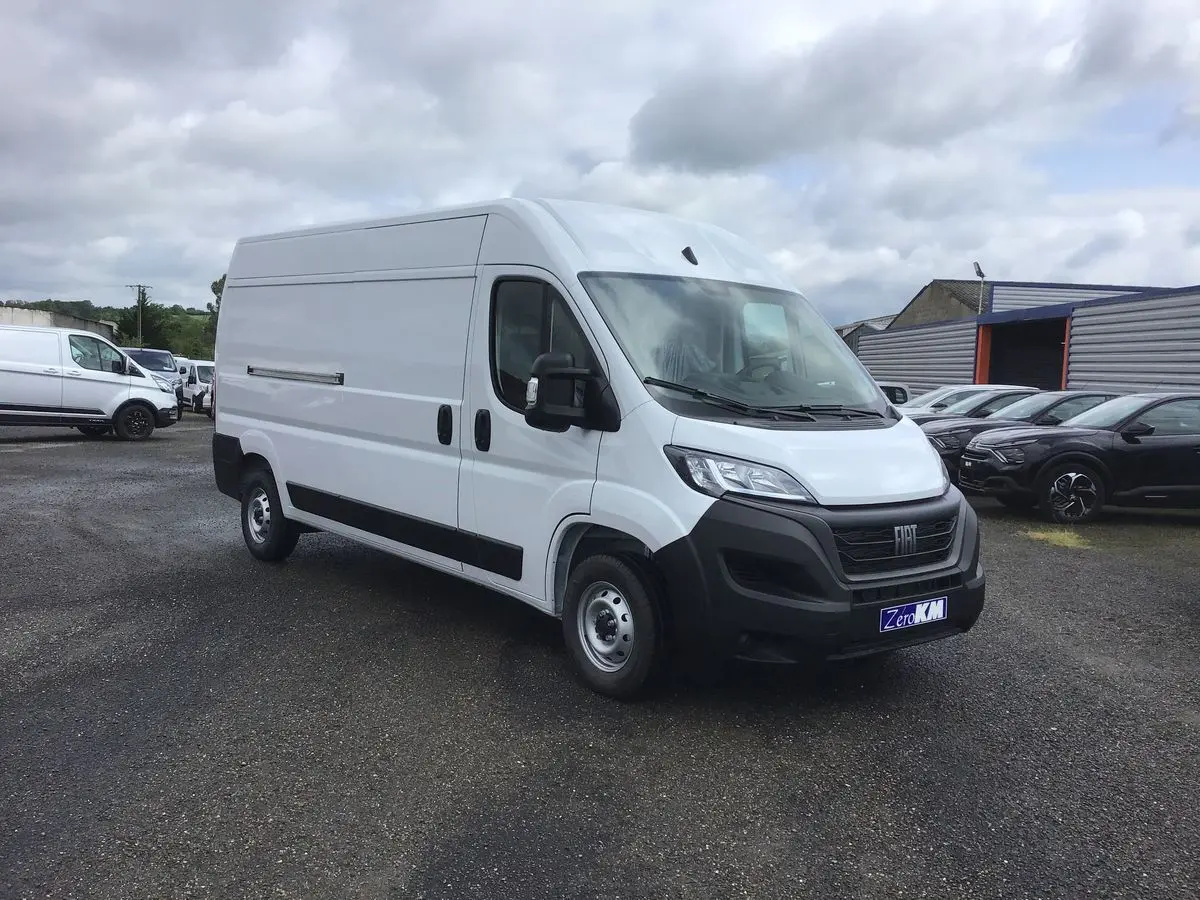 Fourgon blanc FIAT Ducato 35 LH2 vu en 3/4 avant droit sur un parking sous ciel nuageux.