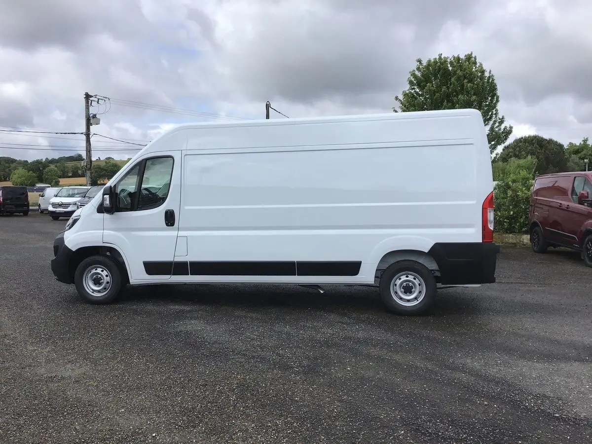 Profil côté gauche d’un FIAT Ducato Fourgon blanc 2023, avec bande noire basse et roues acier simples.