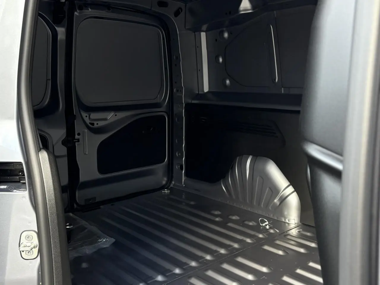 Vue intérieure de la zone de chargement du Citroën Berlingo Van XL gris Artense avec porte latérale ouverte.