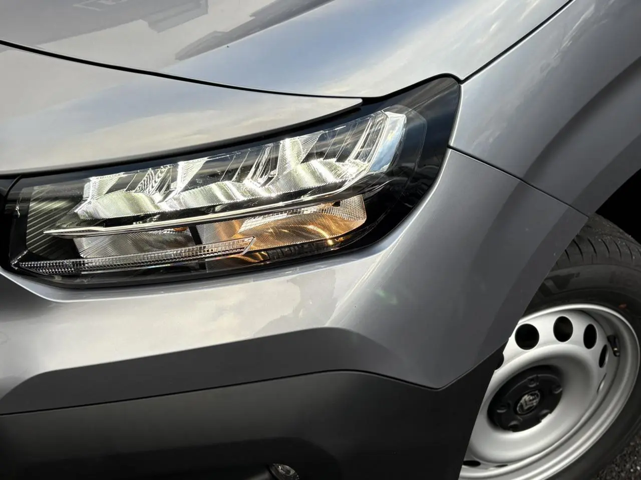 Gros plan sur le phare avant droit et la jante acier grise du Citroën Berlingo Van XL gris Artense 2025