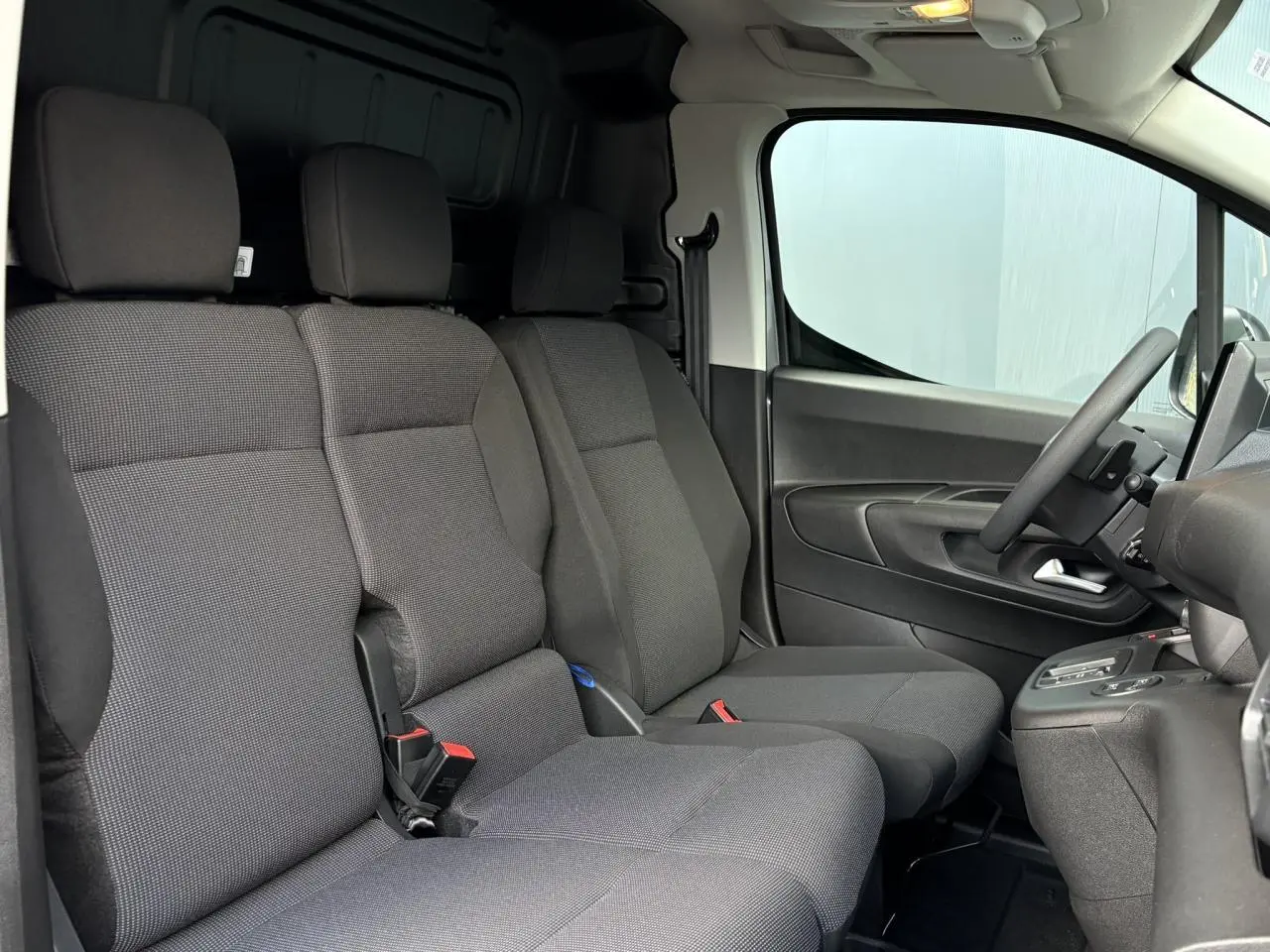 Vue intérieure côté conducteur du Citroën Berlingo Van XL 2025 avec sièges tissu gris et volant multifonctions.