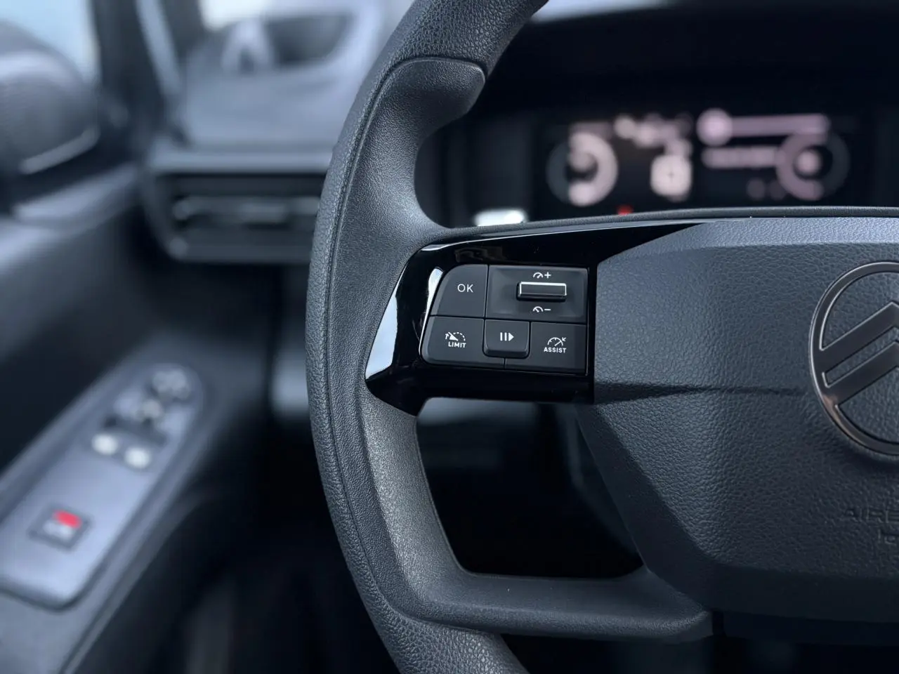 Gros plan sur le volant multifonctions du Citroën Berlingo 2025, avec commandes de régulateur et limiteur de vitesse.