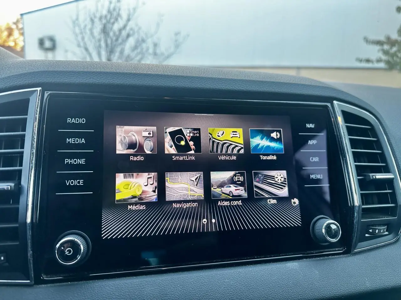 Écran tactile central du Skoda Karoq 2024 affichant le menu principal, vue intérieure frontale.