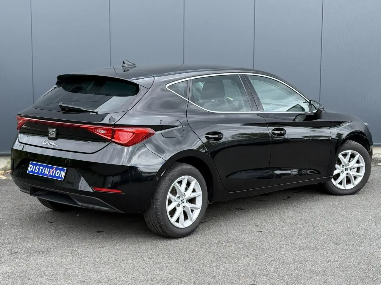 SEAT Leon noir Minuit vue 3/4 arrière droit, jantes alliage 16 pouces et feux arrière LED distinctifs.