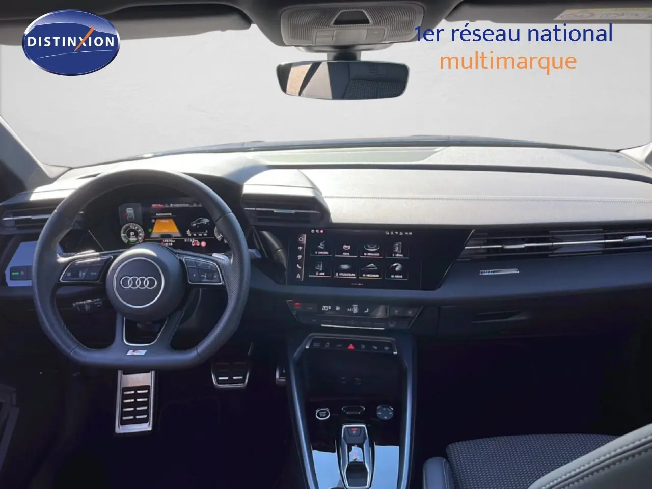 Vue intérieure frontale de l'Audi A3 Sportback 2025, tableau de bord noir avec écran tactile et volant multifonction.