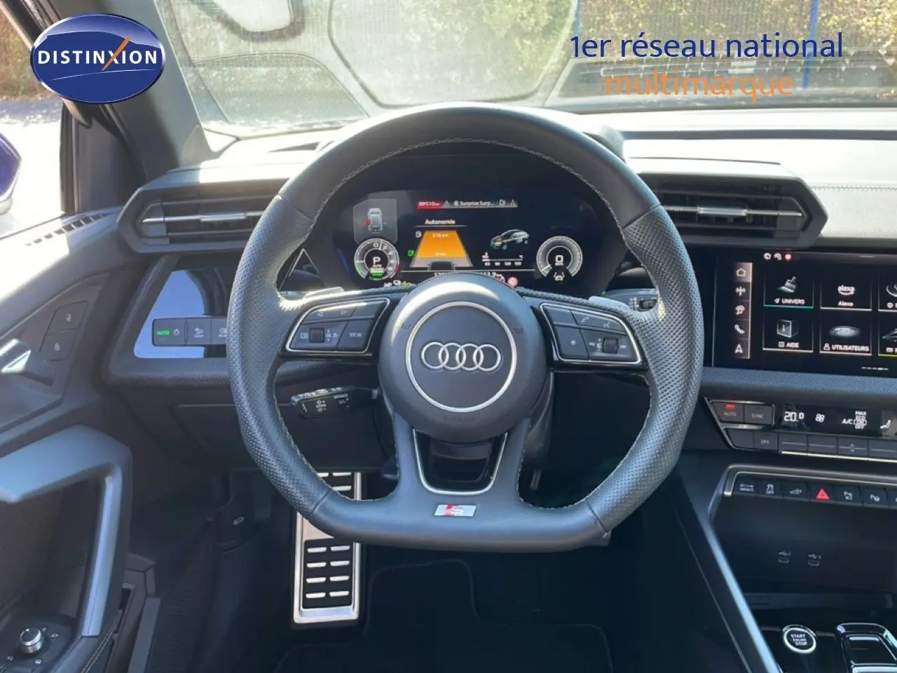 Vue intérieure centrée sur le volant S-Line noir perforé et le tableau de bord numérique de l'Audi A3 Sportback 2025.