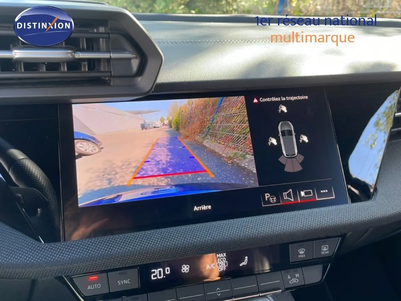 Vue intérieure du tableau de bord de l’Audi A3 Sportback bleu Navarre, écran affichant la caméra de recul et les commandes climatiques.