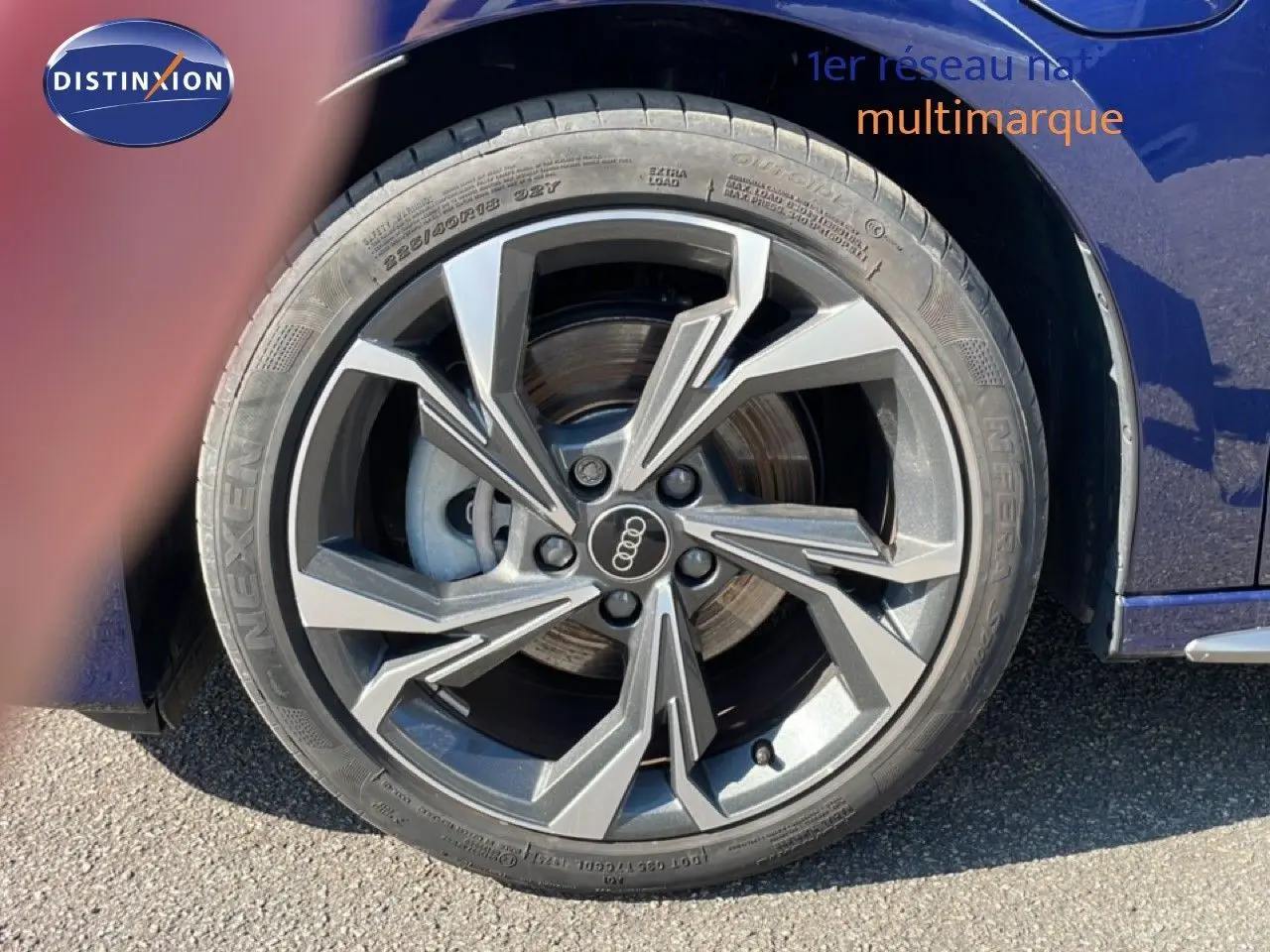 Gros plan sur la roue avant droite d'une Audi A3 Sportback bleu Navarre métal avec jante alliage au design moderne.