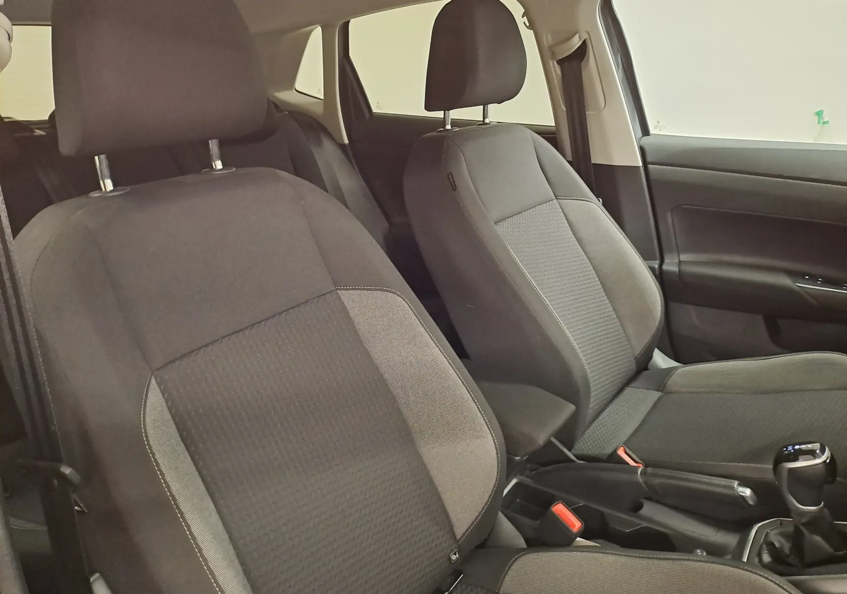 Vue intérieure des sièges avant en tissu gris de la Volkswagen Polo 1.0 TSI 95 VW Edition 2025 avec boîte automatique.